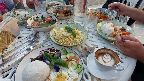 Candid scene of people eating together a hearty lunch featuring authentic traditional local Filipino dishes like tinola or clear soup, adobo and afritada stew 