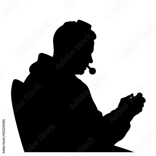 Silhouette of a person gaming with headphones, focused concentration