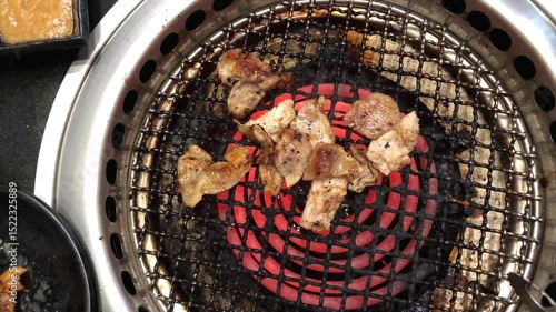 Meat slides are gilling on electric stove in bbq Korean restaurant 