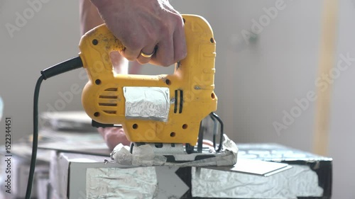 An electric jigsaw cuts quartz vinyl in an apartment. Repair work in the apartment using a saw. Cutting tiles indoors. High quality 4k footage