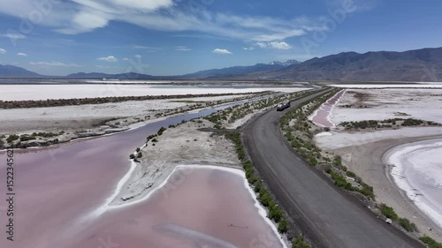 Aerial Great Salt Lake Utah evaporative mining road 1. Solar evaporation produce salts, brine, potassium, magnesium. Largest salt water lake western hemisphere. Dry flat desert Bonneville salt flats.