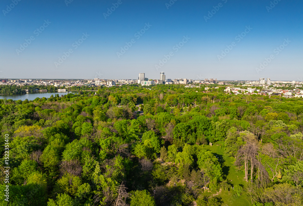 Fototapeta premium King Michael I Park (former Herastrau Park) in Bucharest. Aerial photo with the biggest park in Bucharest. Green forest lake landscape in Bucharest, Romania, during a summer beautiful day.