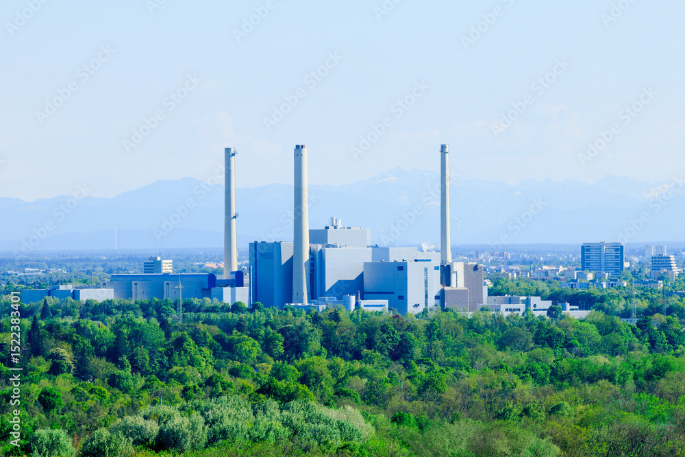 Obraz premium Modern power plant in the middle of a green landscape with a view of the Alps - symbol for energy production, global warming and change towards a sustainable environment - Munich, Germany