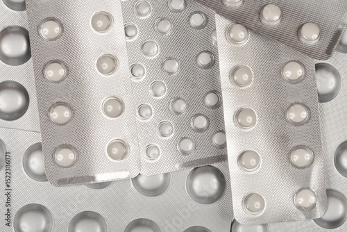 Obraz na plátně A close-up overhead shot of several silver blister packs containing white pills