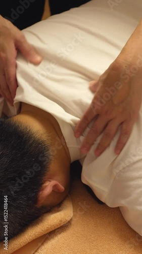 Traditional Japanese massage: Firm shoulder kneading with both hands on a male client