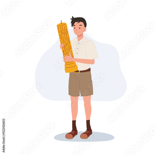 thai schoolboy holding large wax candle for buddhist holiday celebration in thailand cultural festival and asian tradition.