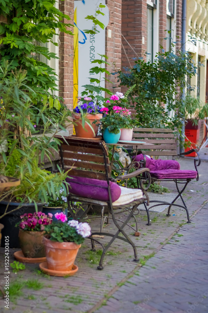 Fototapeta premium Deventer the Netherlands 19.05.2025 A pink metal table and chairs against the background of a wooden wall in the Dutch city of Deventer. High quality photo. High quality photo