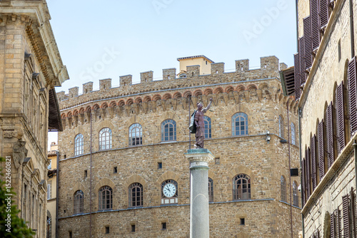 The Column of Justice (Colonna della Giustizia) in Piazza Santa Trinita, with Palazzo Spini Feroni and its clock in Florence, Italy