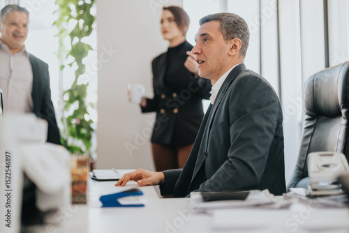 Wallpaper Mural Professionals engaged in discussion within a corporate office. The atmosphere is dynamic and collaborative, emphasizing teamwork. Green plants enhance the workspace, complementing the modern office Torontodigital.ca