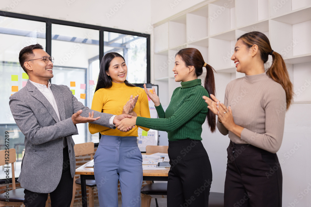 Obraz premium Group of Asian businesspeople talking together and brainstorm standing in modern office, Business startup and company strategy planning concept.