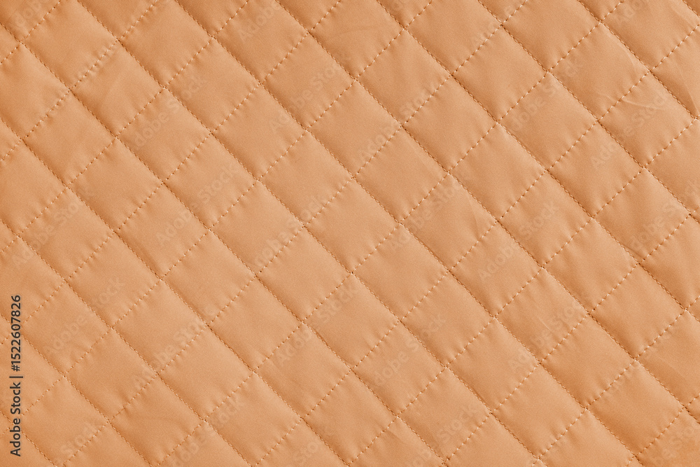 Fototapeta premium Checkered, diamond stitching pattern, orange quilted fabric background. Blanket or puffer jacket, stitch rhombus texture close up, macro. Wallpaper, backdrop.