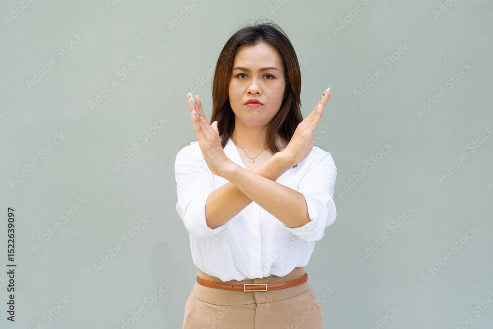 Portrait of Asian woman with business clothes against plain wall making stop sign gesture Portrait of Asian woman with business clothes against plain wall making stop sign gesture