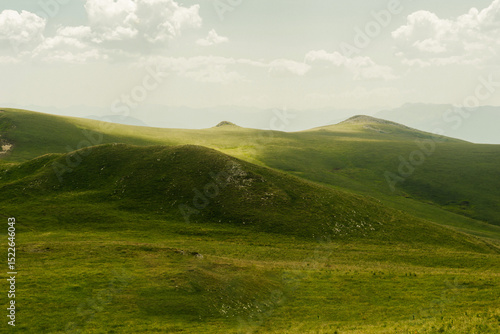 Konstfotografi Mountain landscape with soft green hills and distant forested ridges