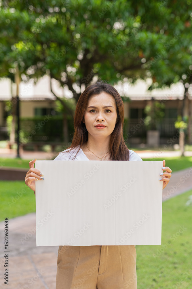 woman holding a blank sign in park woman holding a blank sign in park