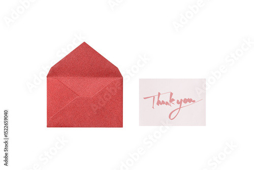 A cutout of a red lamé envelope with a pink handwritten thank you message card, overhead view