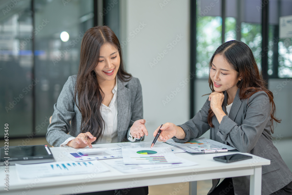 Fototapeta premium Two businesswoman hands or accountants working together on financial investment on calculator, calculating, analyzing business growth and marketing on graph.