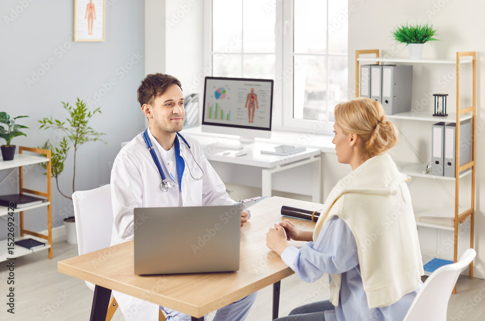 Fototapeta premium Positive male doctor or nurse is in consultation with a female patient in a hospital office, providing medical advice and quality care. Effective communication and healthcare delivery.
