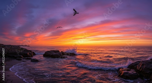 Seaside Sunset with Waves and Birds Flying Over Rocks