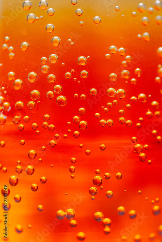 Bright orange liquid filled with fizzy bubbles captures the light
