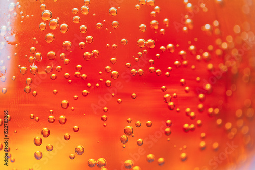 Bright orange liquid filled with fizzy bubbles captures the light