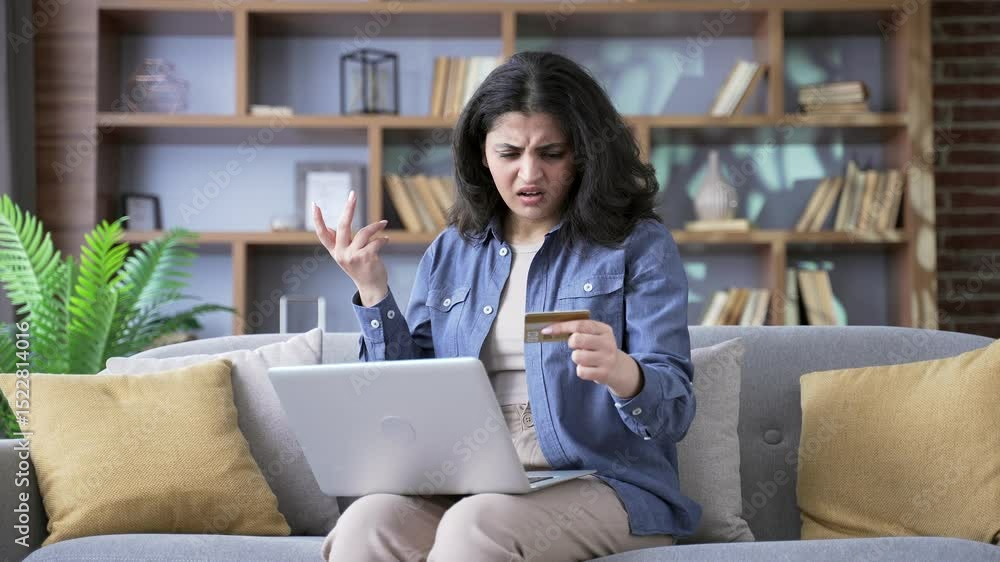 Shocked upset young woman faced fraud checking credit card on laptop sitting on sofa in living room at home. Frustrated female became victim of deception, money had been stolen from her account Shocked upset young woman faced fraud checking credit card on laptop sitting on sofa in living room at home. Frustrated female became victim of deception, money had been stolen from her account