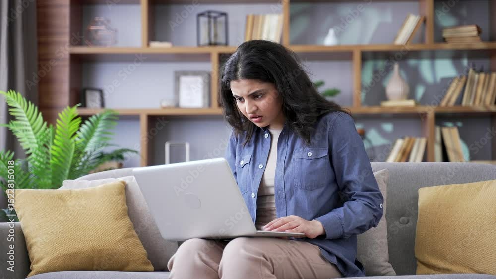Disappointed young woman complains about poor performance of program on laptop sitting on sofa in living room at home. Frustrated upset female is dissatisfied with work of computer Internet or service Disappointed young woman complains about poor performance of program on laptop sitting on sofa in living room at home. Frustrated upset female is dissatisfied with work of computer Internet or service