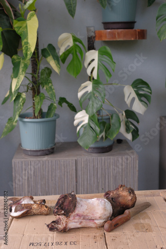The man with a knife cuts a piece of smoked lamb leg