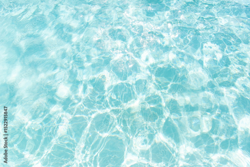 Fototapeta premium Clear turquoise water surface with sun reflections