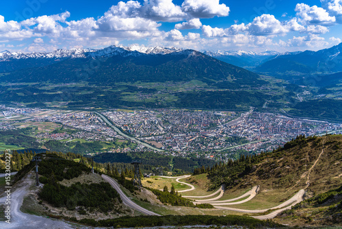 Aerial panorama view of Innsbruck city and Tyrolean alps from Seegruben cable car station in spring on a sunny day, Innsbruck, Austria