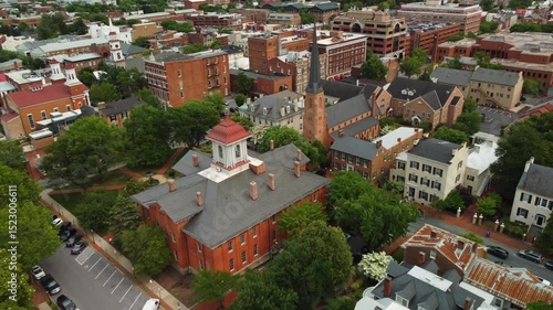 Front-facing aerial drone shot of downtown Frederick, Maryland. Shows historic buildings, streets, and city layout on a clear day.