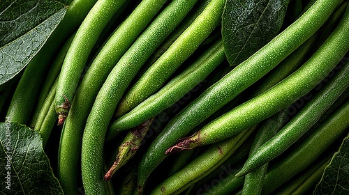 A table with two piles of green beans, one on top of a green leaf and the other next to it