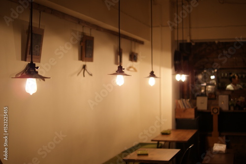 工業系デザインのペンダントライトが連なるカフェの温かな空間

