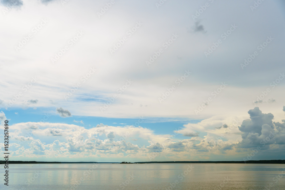 Fototapeta premium Grey rainy clouds over the lake. Dense forest along the lake shore during a storm.