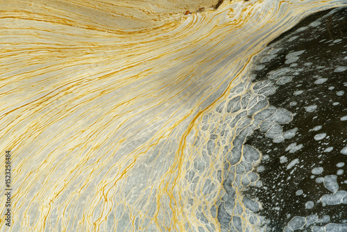 Dirty foam on the surface of the water. Pollution of water bodies by waste from the chemical industry. Environmental pollution, background.