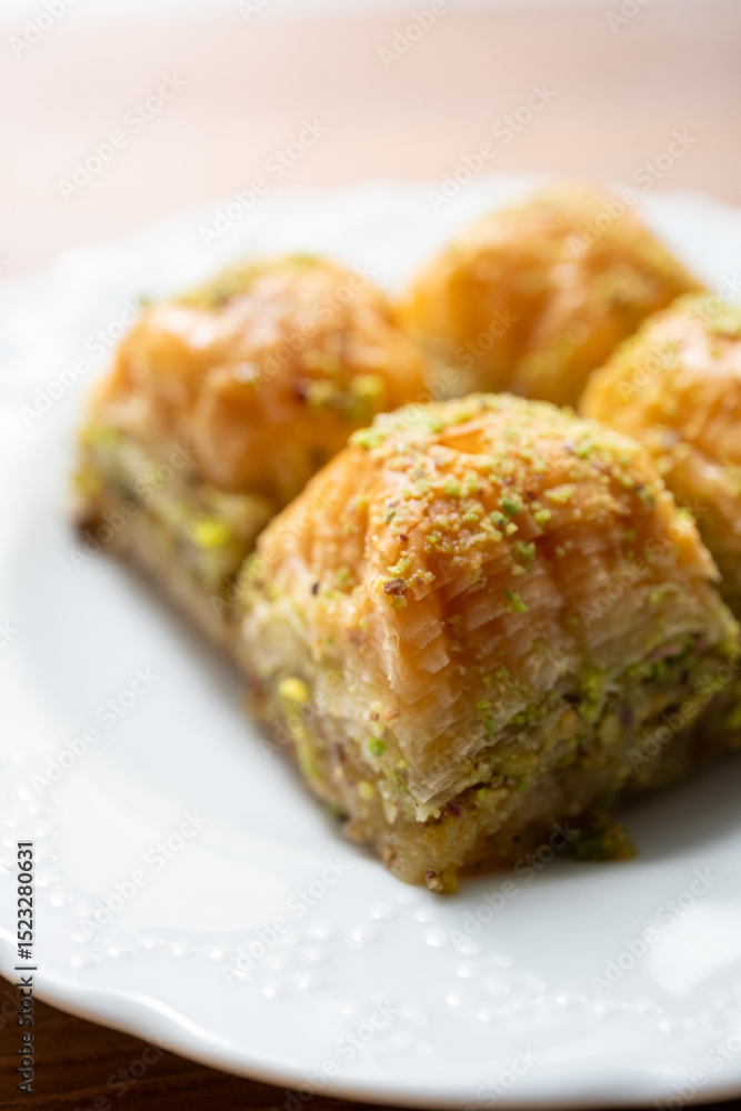 Traditional Turkish homemade baklava on white plate in close-up Traditional Turkish homemade baklava on white plate in close-up