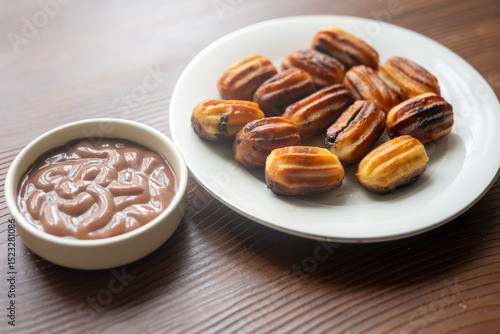 Close-up of churros dessert on a white vintage plate and hot chocolate