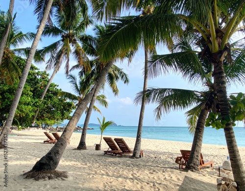 Idyllic beach scene with palm trees and lounge chairs in Koh Samui Thailand