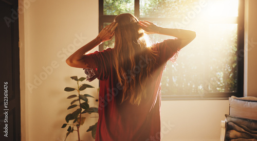 Foto Back, woman and stretching by window for sunshine, freedom and ready to start day in house