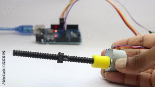 Stepper motor with its shaft connected to a 3d printed part is being rotated and it is controlled by micro controller on background