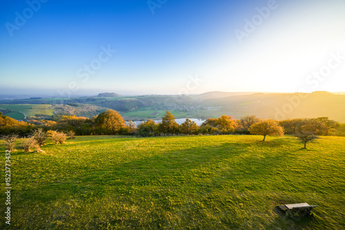 View of the landscape at the Meerfelder Maar. Nature at the crater lake in the Volcanic Eifel National Park. The surrounding area near Meerfeld at sunset in the evening.
