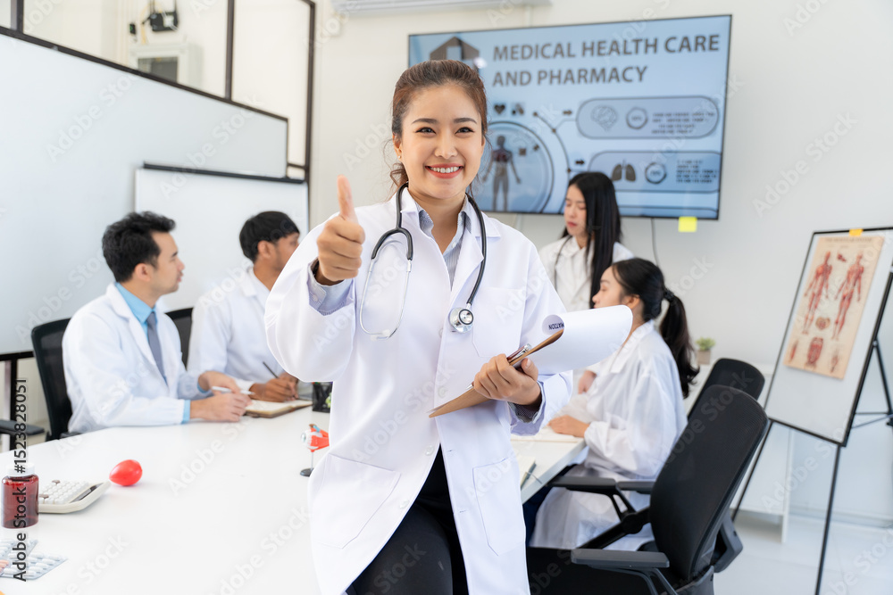 Fototapeta premium Confident Asian Doctor Giving Thumbs Up in Meeting