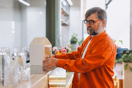 Fotografi Senior man preparing pastry box in a cake shop