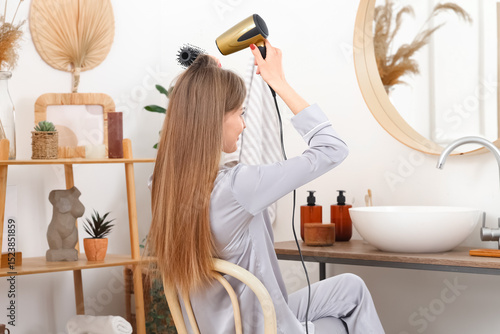Young woman drying her hair...
