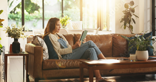 Obraz na płótnie Tablet, relax and woman on sofa in home for reading online blog, newsletter or research on plants
