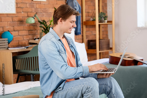 Male student using laptop i...