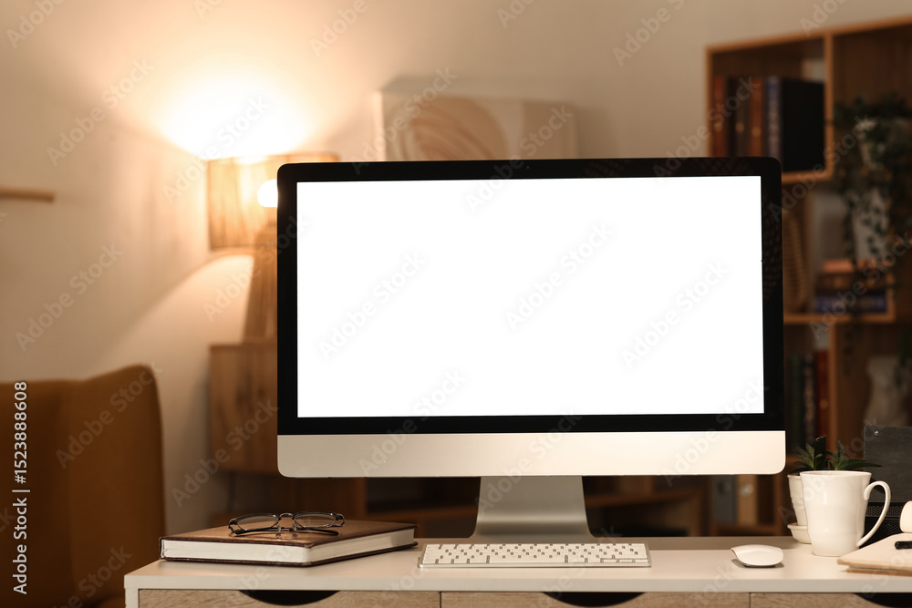 Fototapeta premium Blank computer monitor on desk in dark office