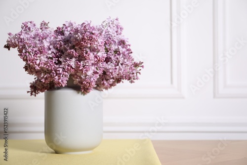 Wallpaper Mural Beautiful lilac flowers in vase on table near white wall indoors, space for text Torontodigital.ca