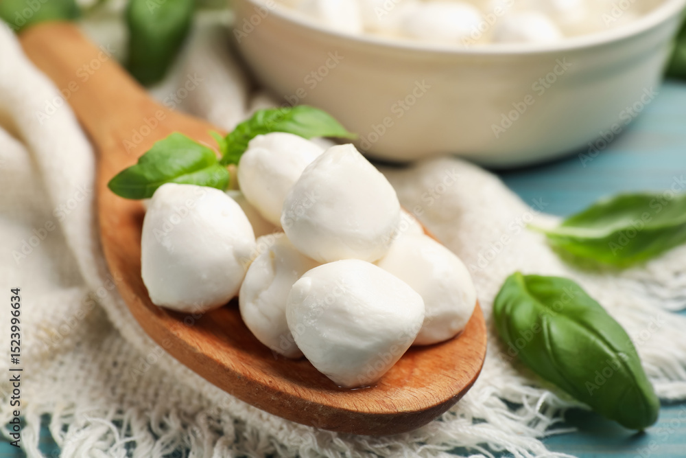 Mozzarella cheese balls and basil on blue wooden table, closeup Mozzarella cheese balls and basil on blue wooden table, closeup
