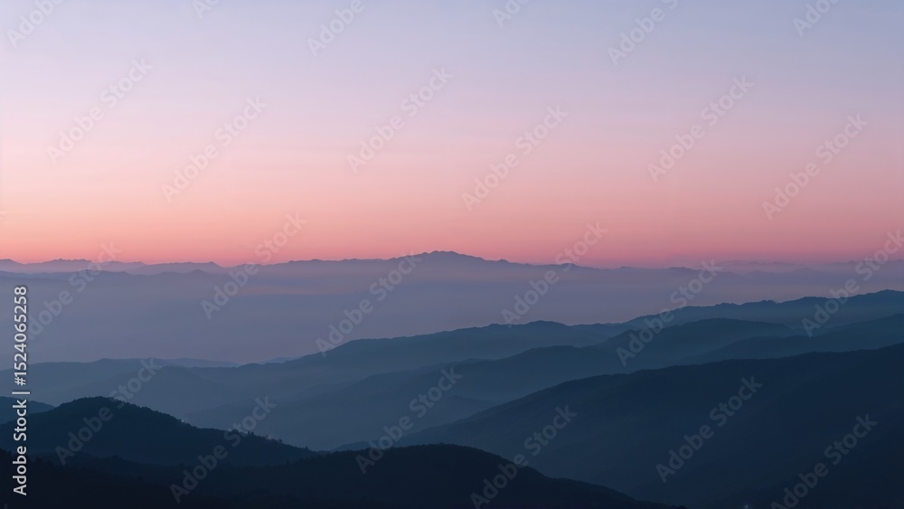 Obraz premium Misty mountain range landscape during a serene pink and purple sunset.