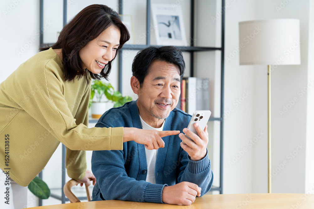 Fototapeta premium スマホを見るミドルの夫婦